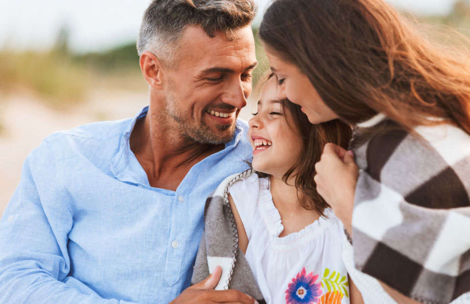 child smiling with her parents after visiting the dentist in Smithtown, NY